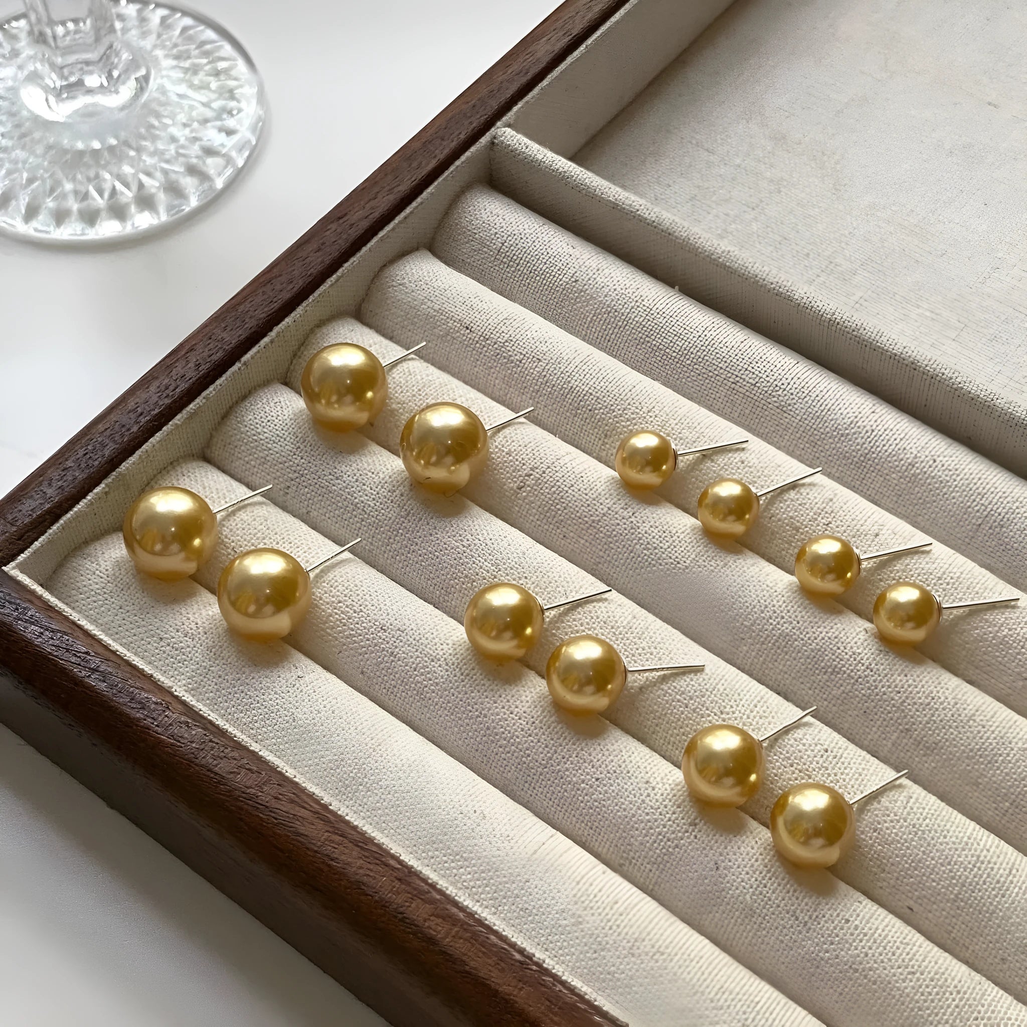 A pair of large geometric pearl stud earrings with a retro design on a silver setting.
