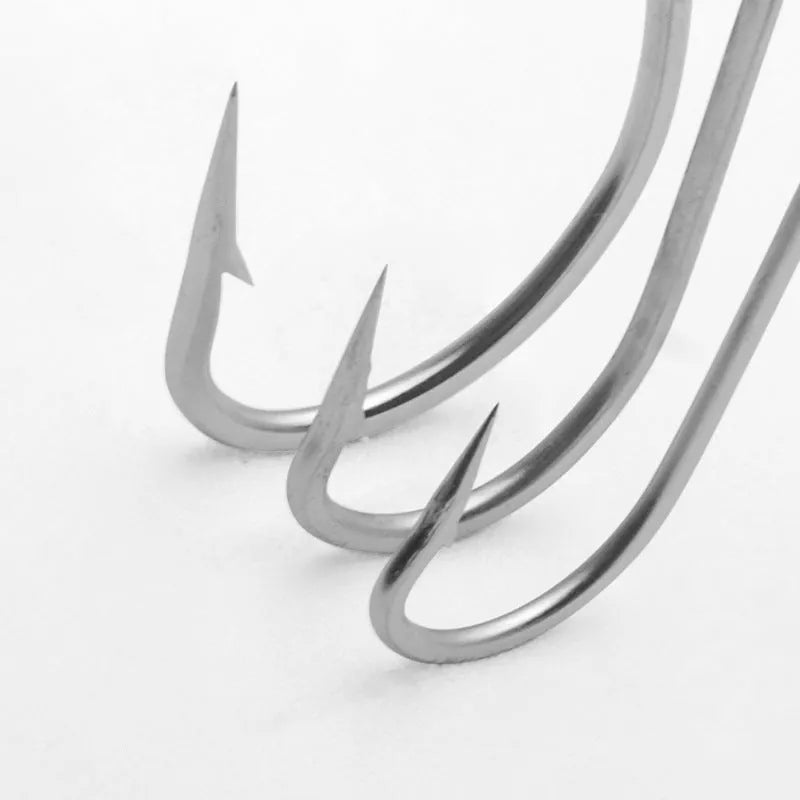 Assortment of stainless steel alloy fishhooks for sea fishing on a blue background.