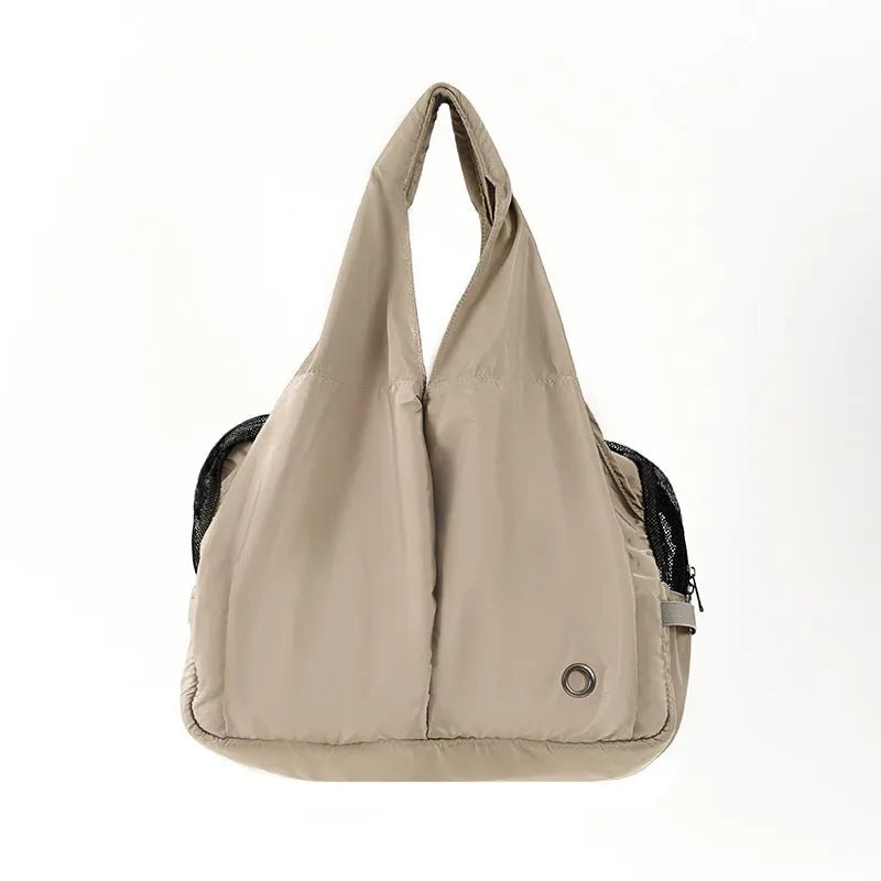 Apricot-colour cloth pet carrier handbag with mesh panels and a shoulder strap.