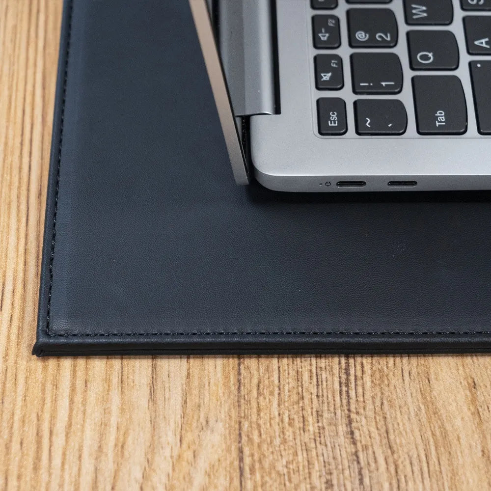 Durable black laptop cooling pad with printing pattern and anti-radiation features on a desk.