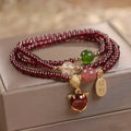 Purplish red adjustable rope bracelet with a detailed natural garnet fox charm.