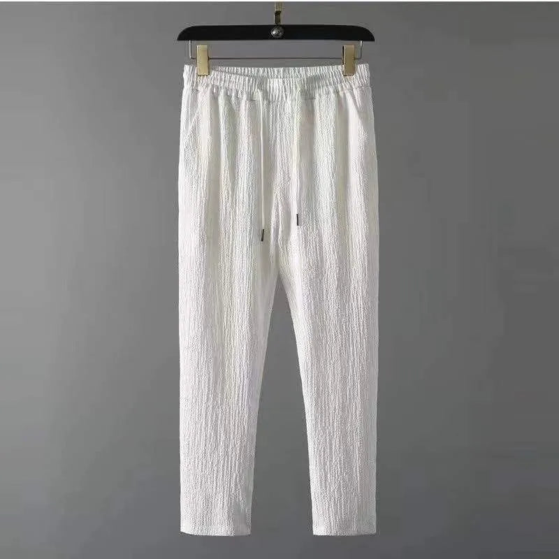 Men's summer leisure suit with loose short sleeve top and drawstring trousers in black or white polyester