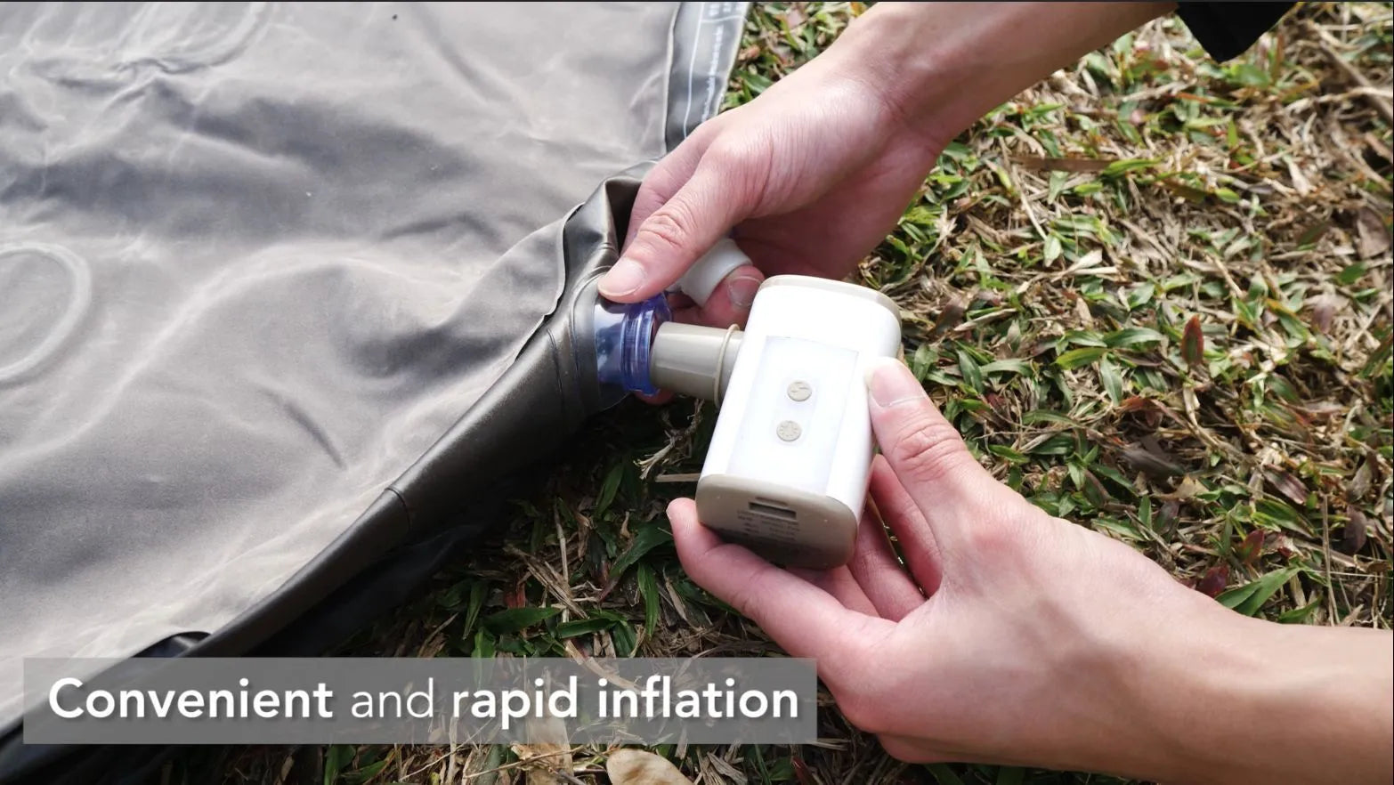 Portable mini motor pump in khaki white with USB cable and three air nozzles on a camping table