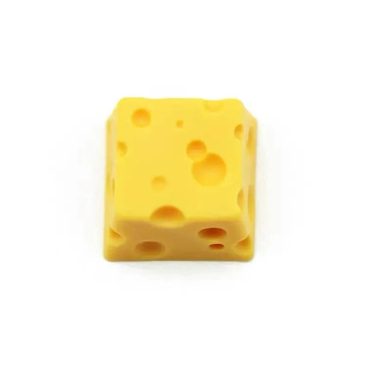 Yellow resin cheese-shaped key cap for mechanical keyboards, shown from a top-down angle.