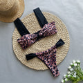 Women's leopard print bandeau bikini set with split top and T-pants bottoms.