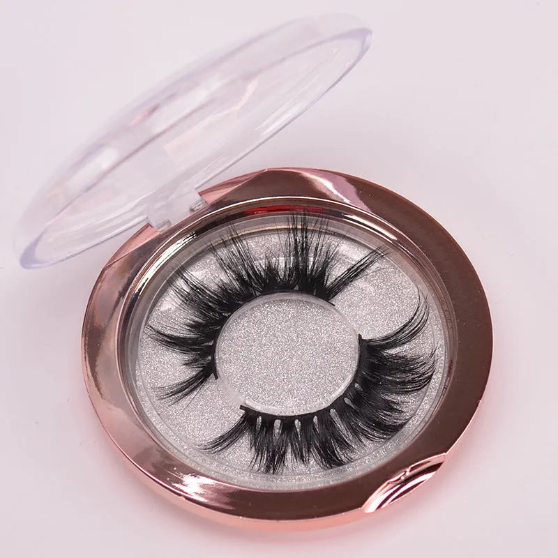 Hand-made 5D mink false eyelashes set with protective cap and dual-ended brush on a clean background