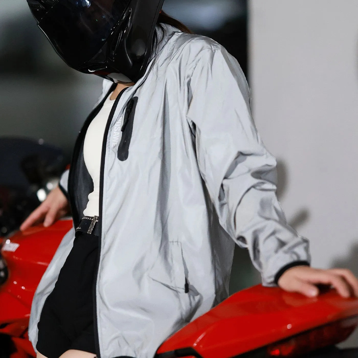 Silver waterproof polyester long sleeved jacket showing front view with size label indicating Asian and European conversion