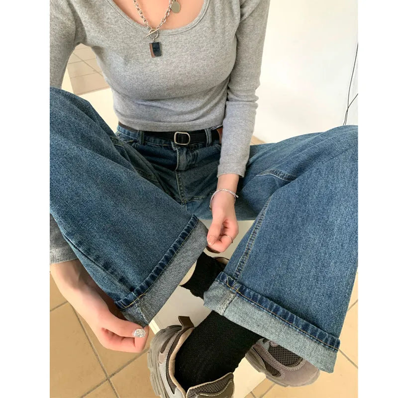 A woman wearing high-waist straight leg jeans in a retro blue colour, showcasing the classic denim fit.