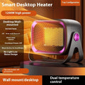 A compact grey desktop electric heater with a rotatable base on a table.