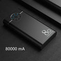 Black 20000mAh alloy portable power bank with LED flashlight showing size scale