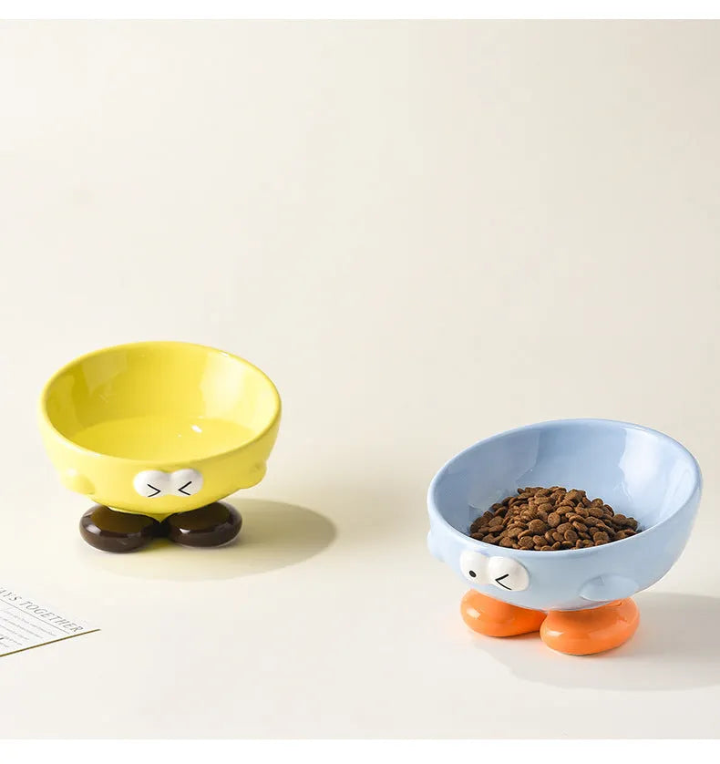 Blue ceramic pet bowl with tall, angled sides and a cute face design for cat or small dog feeding.