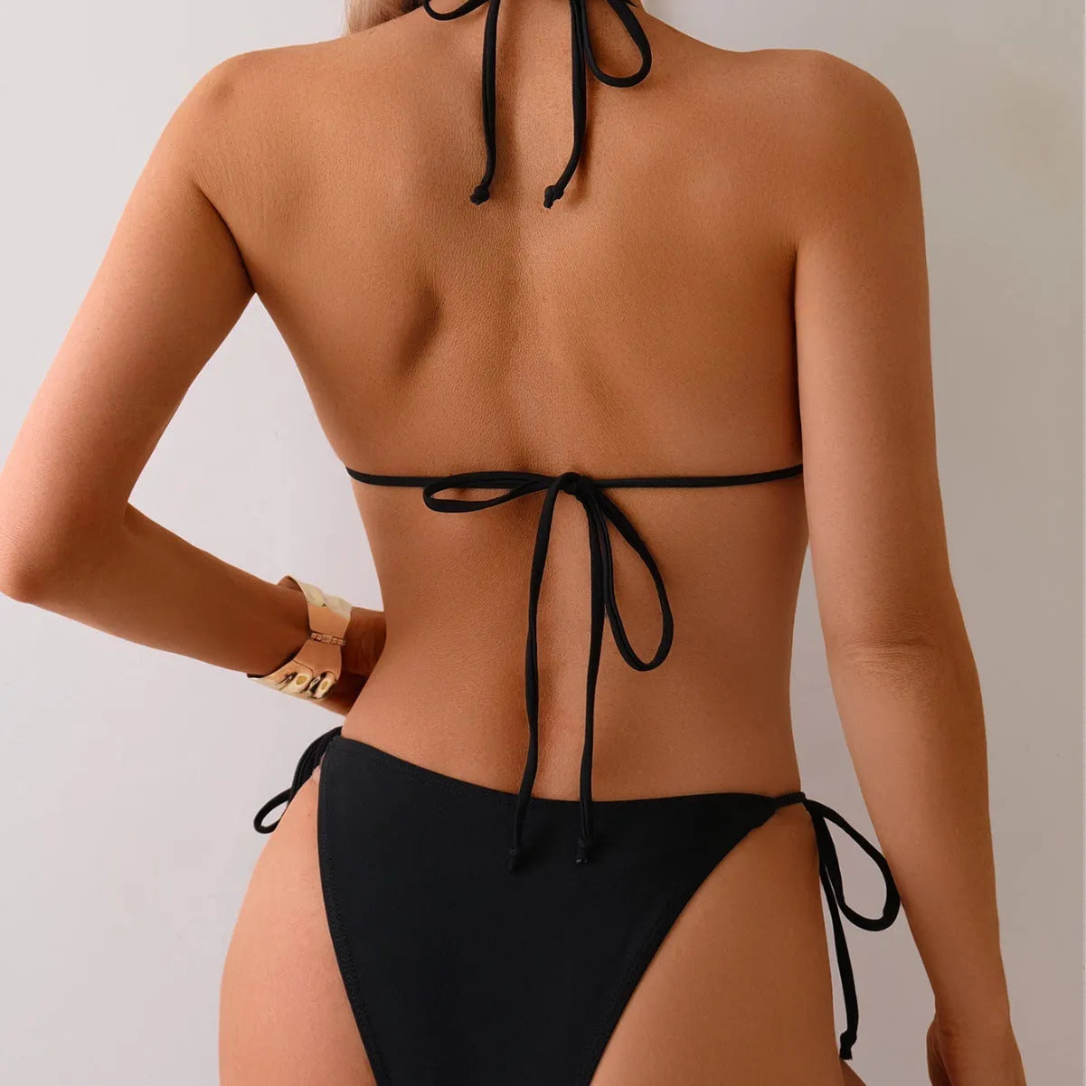 Black women's bikini swimsuit with metal bead decoration on the fabric.
