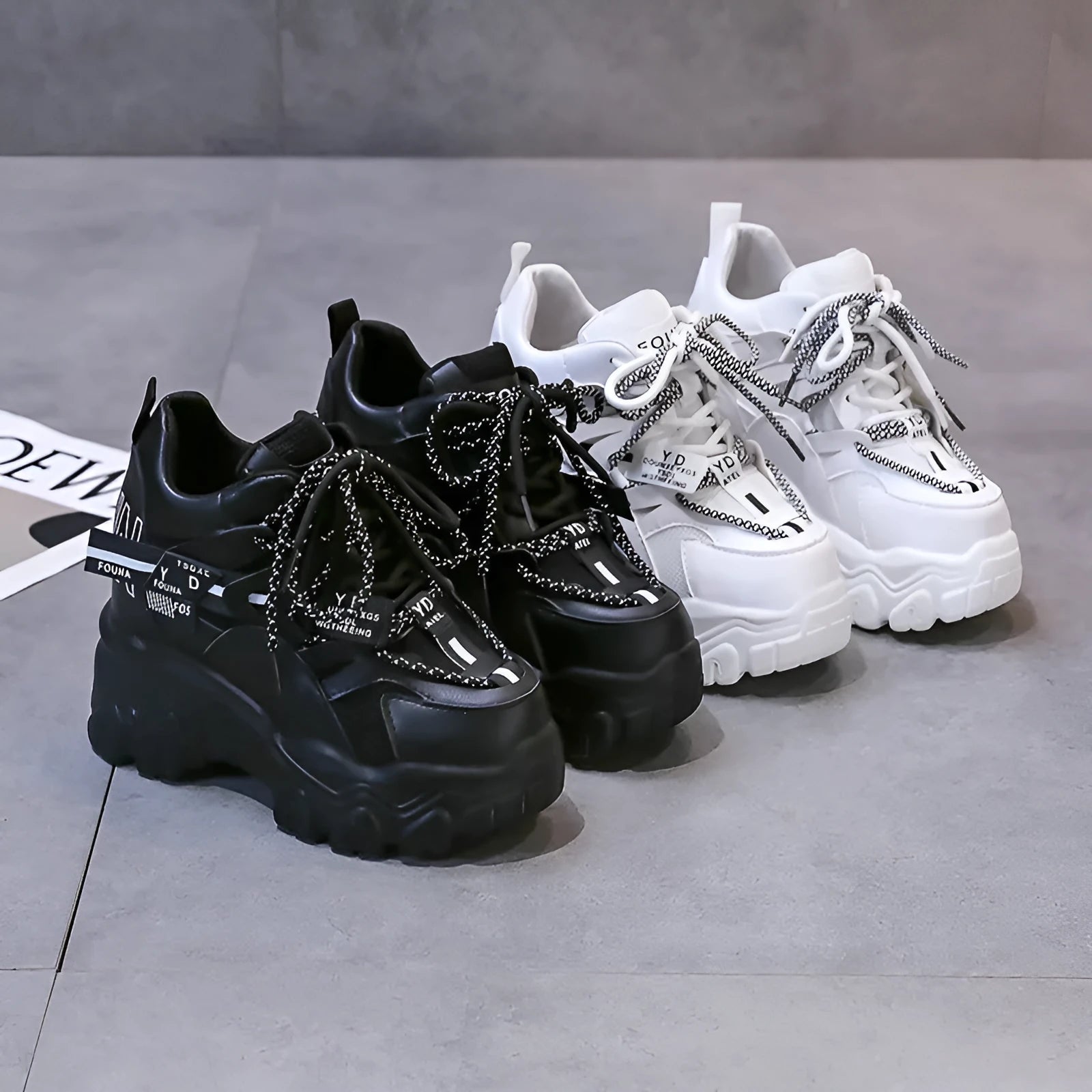 White women's low-top platform sports shoes with a cross-strap over a shallow-cut collar and a thick rubber sole.
