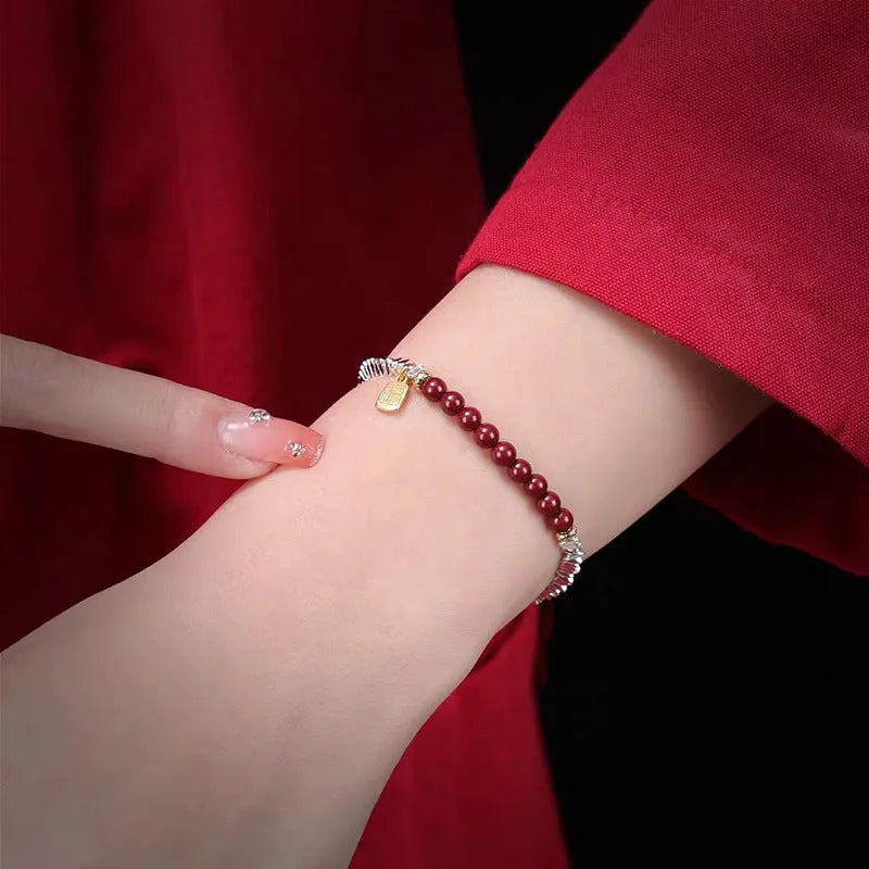 Silver-toned couple bracelet with geometric charm and round beads on white background