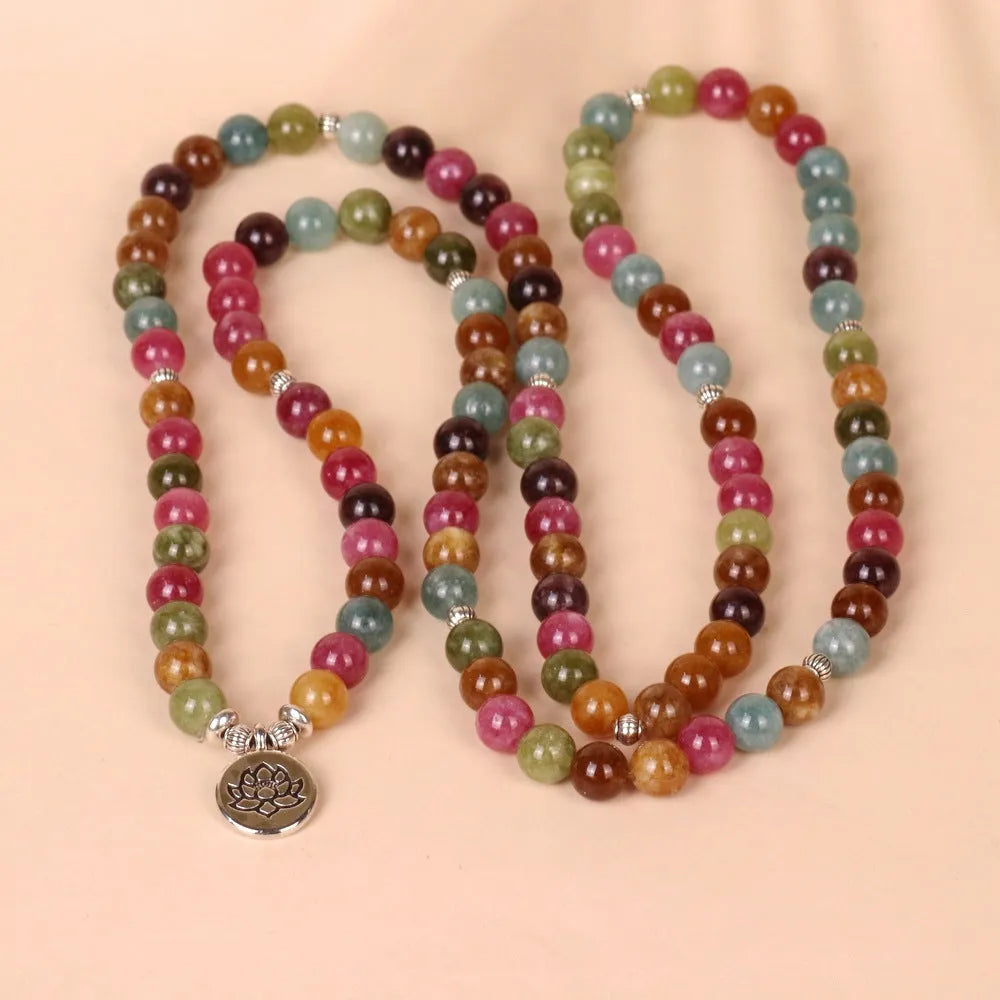 108 bead multi-layer bracelet in tourmaline colour with alloy details on a wrist.