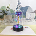 Small glass cover night lamp with plastic base and multiple LED colour options on a table.