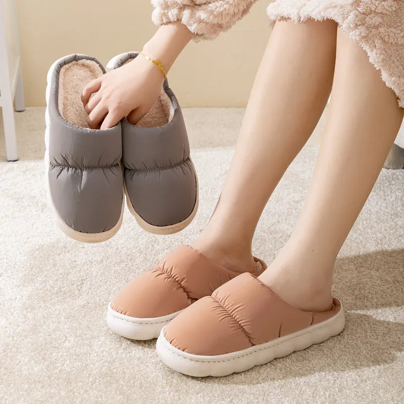 A pair of thick-soled house slippers with an artificial leather upper and plush lining, shown in a selection of colours.