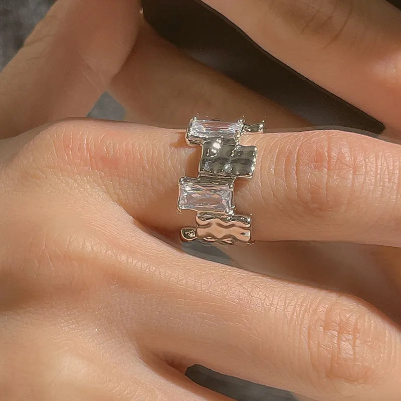 Silver cross ring with geometric design and open gemstone setting