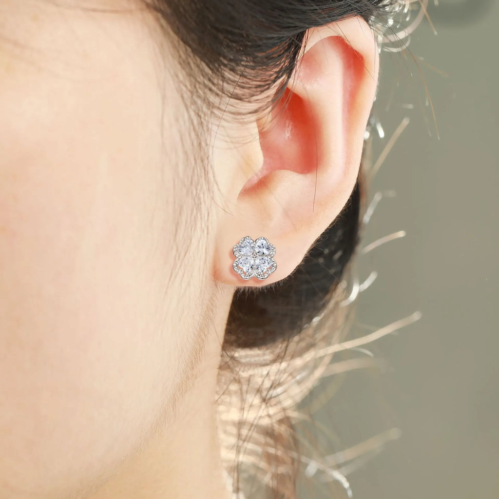 A pair of 925 silver earrings with a heart and four-leaf clover design, set with zircon stones in a white gold colour finish.
