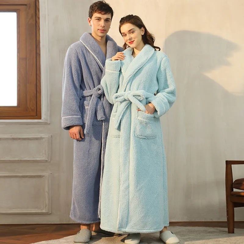 Man and woman wearing matching thick navy blue flannel bathrobes, showcasing the extended length and winter fabric.