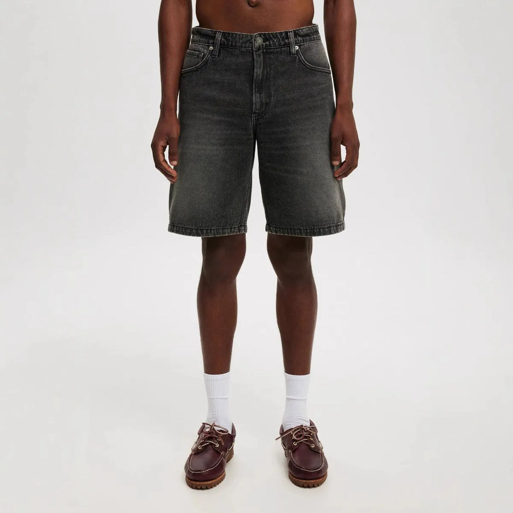 Men's loose straight-leg light blue jeans on a neutral background
