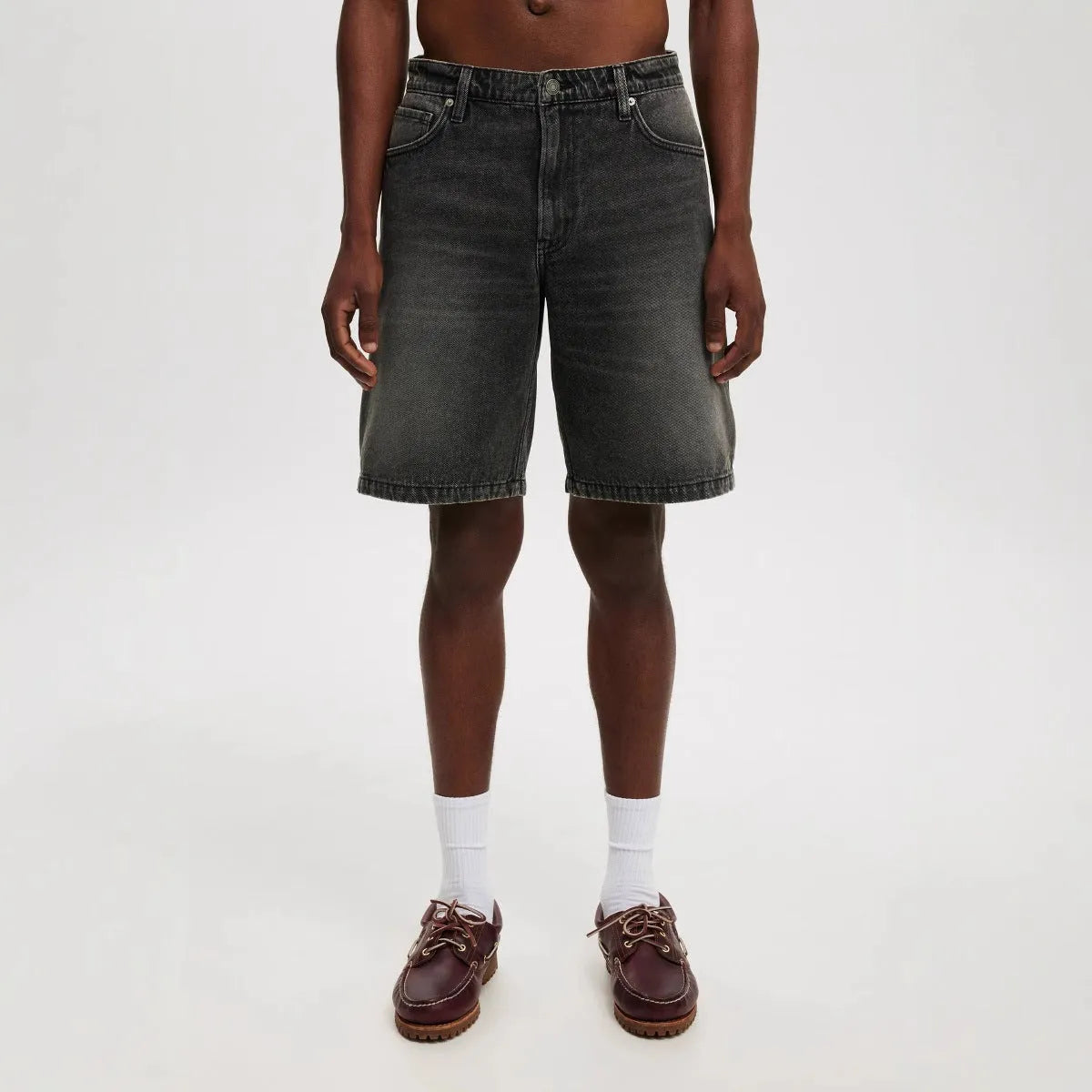 Men's loose straight-leg light blue jeans on a neutral background