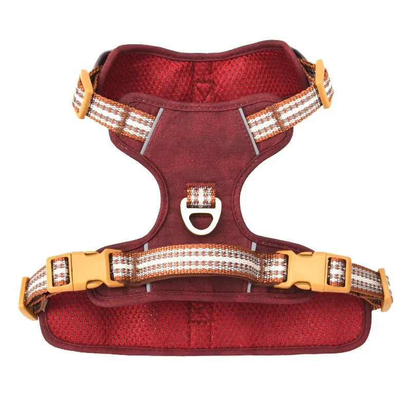 Brown leather dog harness with reflective strips and chest clip.