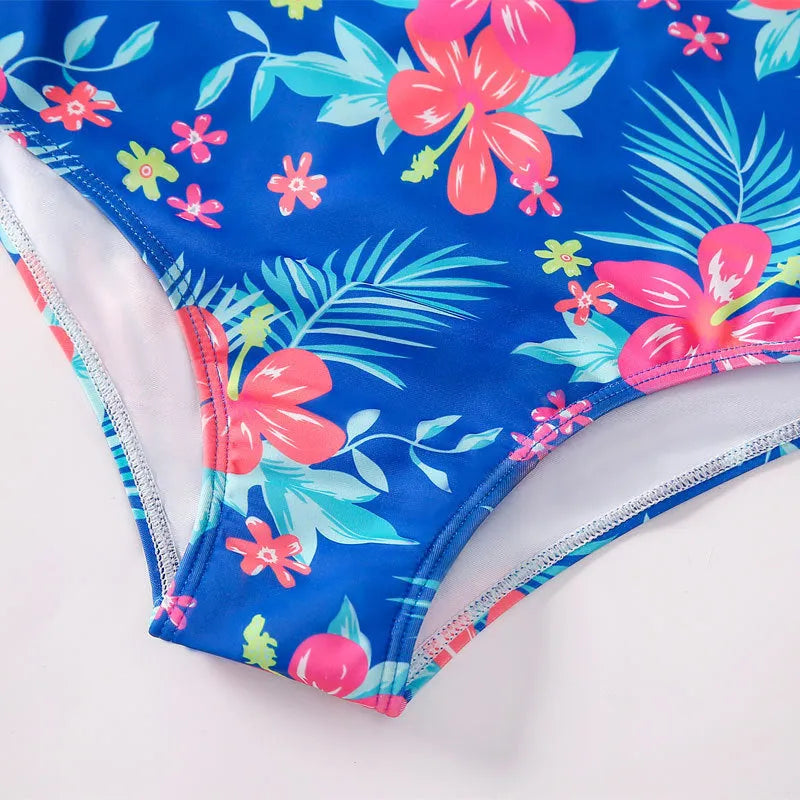 Girl's long sleeve one piece swimsuit in a briefs style on a hanger.