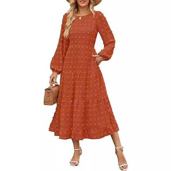 A woman wearing a beige high-waist long sleeve dress with ruffle detailing on the sleeves.