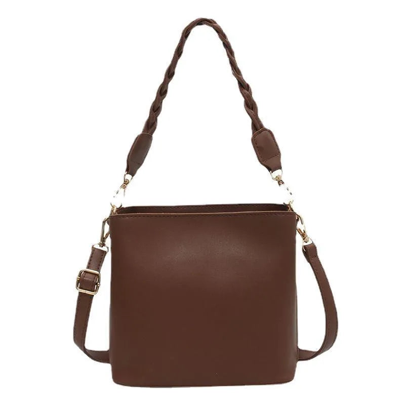 Retro style khaki woven PU leather crossbody bucket bag with an adjustable strap, shown in a casual setting.