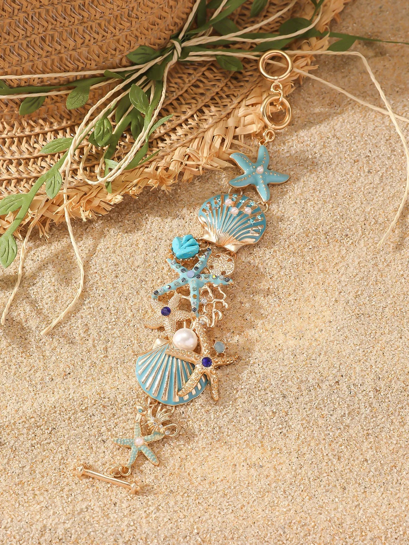 Women's alloy nautical bracelet with boat anchor, shell, and starfish charms in turquoise, red, or blue.