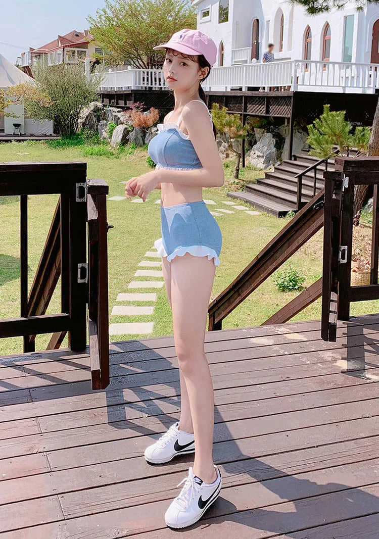 Solid-colour women's one-piece swimsuit with fashionable suspender straps, conservative cut.