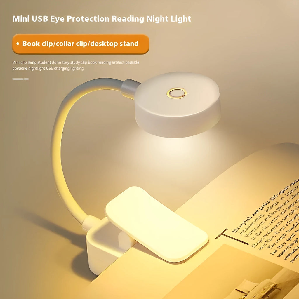 White plastic rechargeable LED book clip light clipped onto a book with USB charging cable