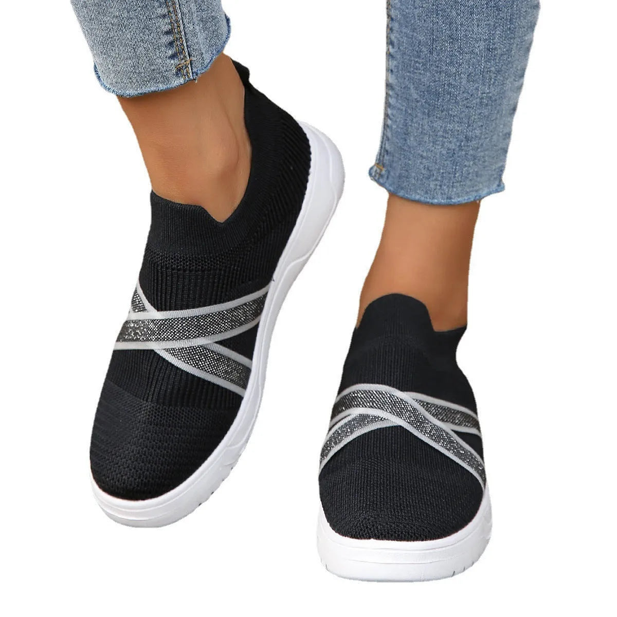 Black women's flat casual shoes with flyknit mesh upper and tassel detail on a flat rubber sole.