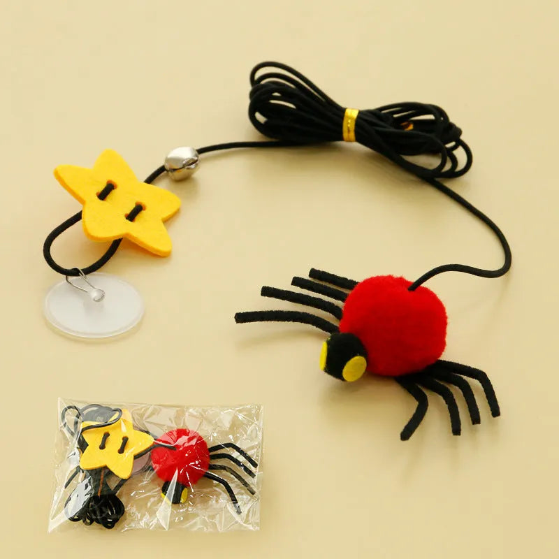Red hanging cat toy with elastic rope, feathers, and bell spider ornament mounted on door