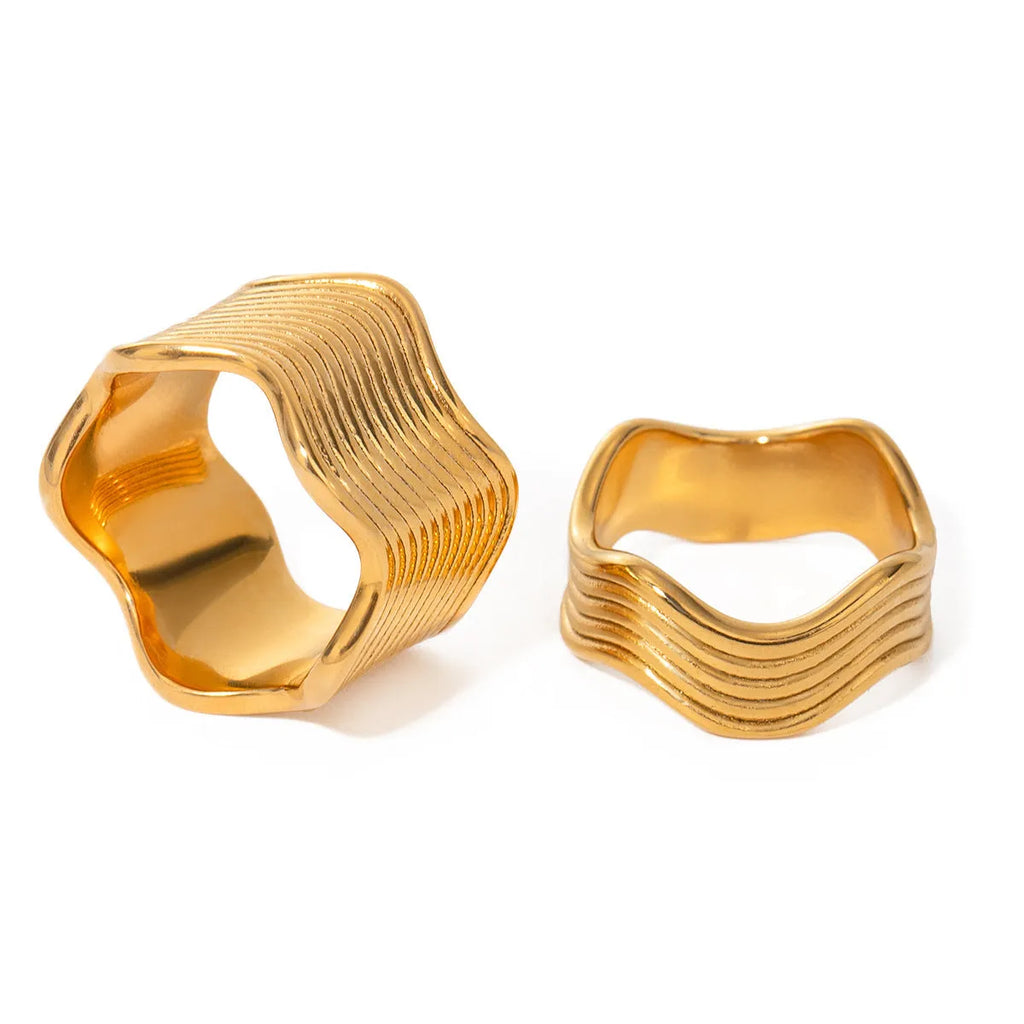 Stainless steel women's ring with wide geometric wave pattern in silver or gold tone.