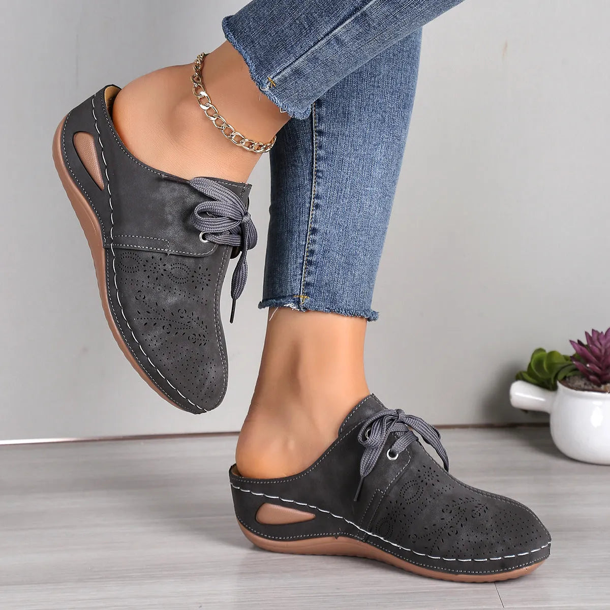 Women's black suede lace-up wedge slippers with hollow-out design and rubber sole.