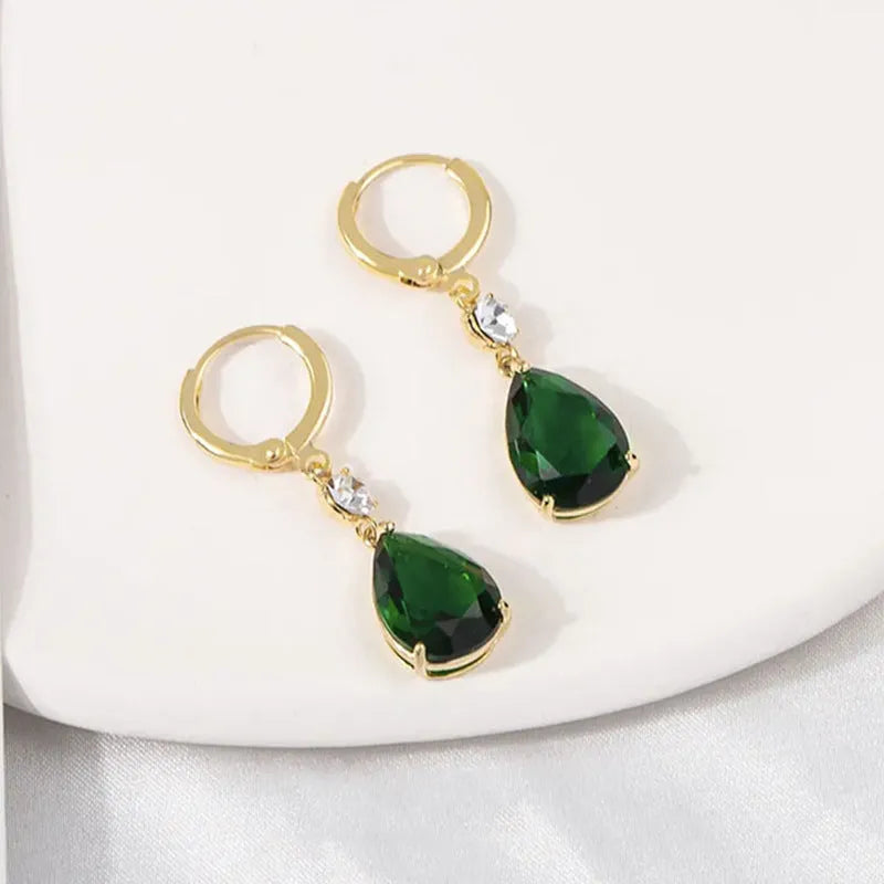 A pair of green geometric teardrop-shaped alloy fashion earrings on a plain background.