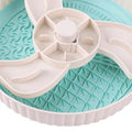 Grey interactive pet slow feeder bowl with rotating centre holding a green silicone licking mat on a kitchen floor.