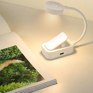 Portable rechargeable clip light in modern simplicity style clipped onto a desk for reading