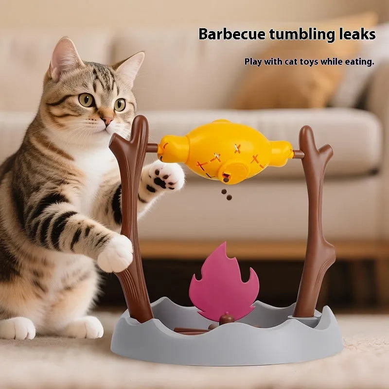 Barbecue-themed plastic tumbling cat treat feeder toy on a floor.