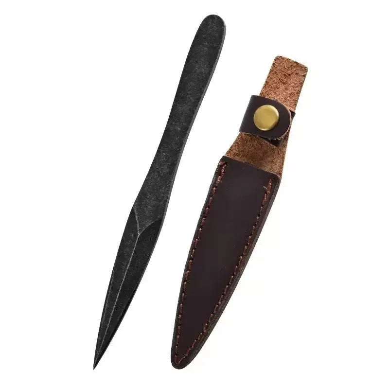 Black stainless steel hand pry tea knife on dark surface with tea leaves