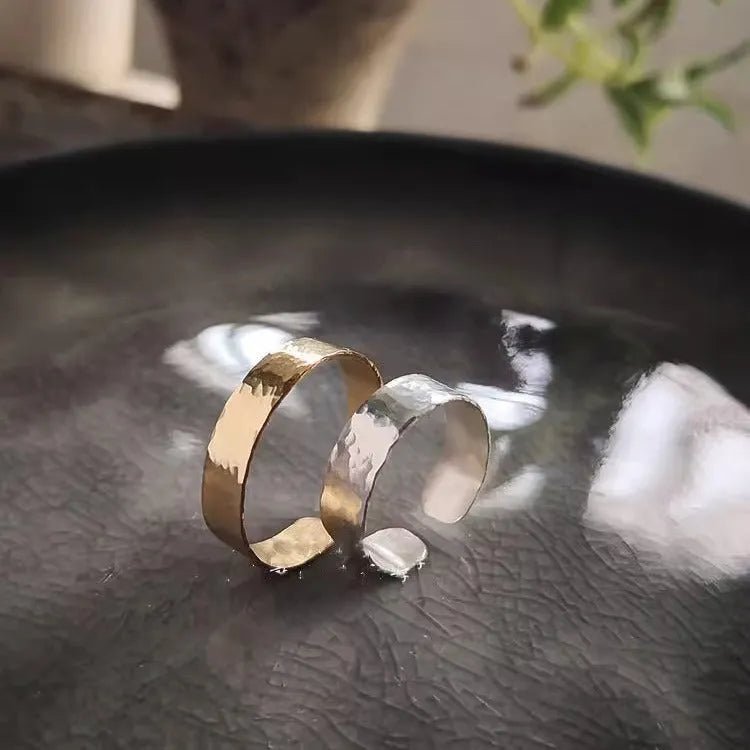 Golden hand-hammered alloy toe ring with open design on a woman's foot