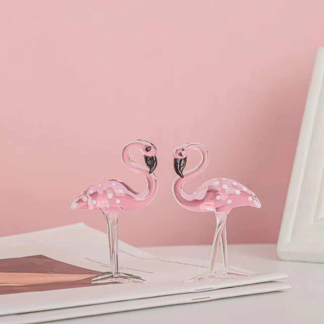 Pink flamingo decorative ornament made of white crystal on a table.