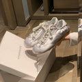Women's champagne pink satin ballet flat shoes with a round toe and white front lace-up detail.