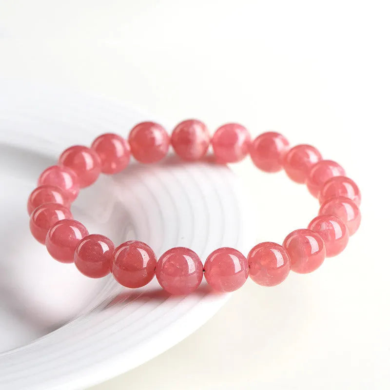 Close-up of a women's geometric red crystal bracelet with a longevity lock on a wrist.