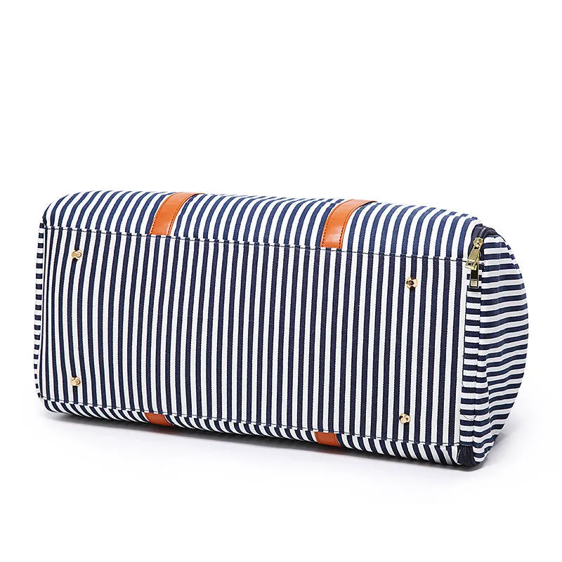 Large striped canvas travel duffel bag with contrast colour and leather detailing, horizontal square shape and zip top.