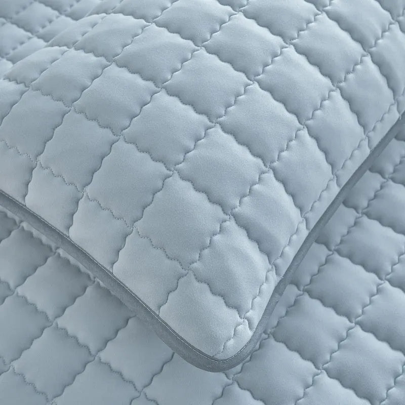 Blue waterproof fitted sheet with elasticated corners on a mattress.