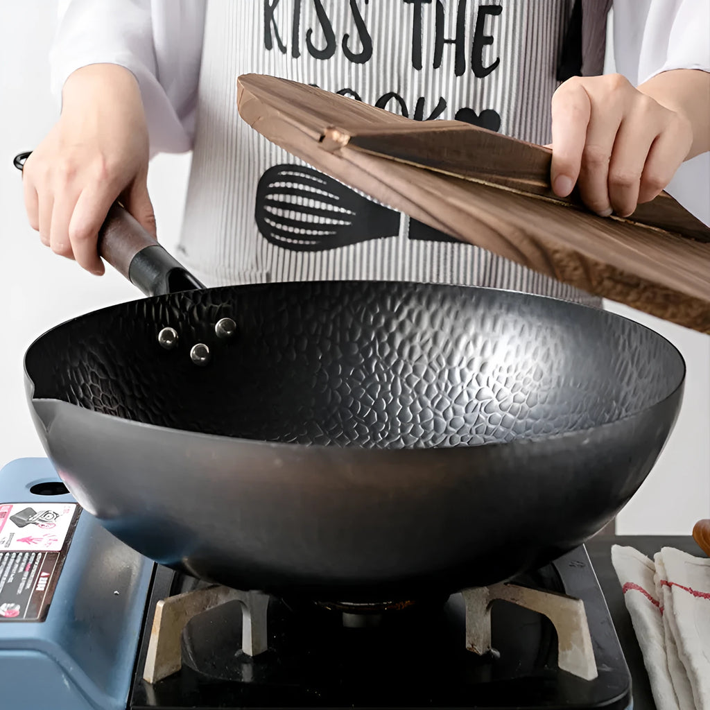 Black handmade iron wok with wooden handle, 32cm diameter.