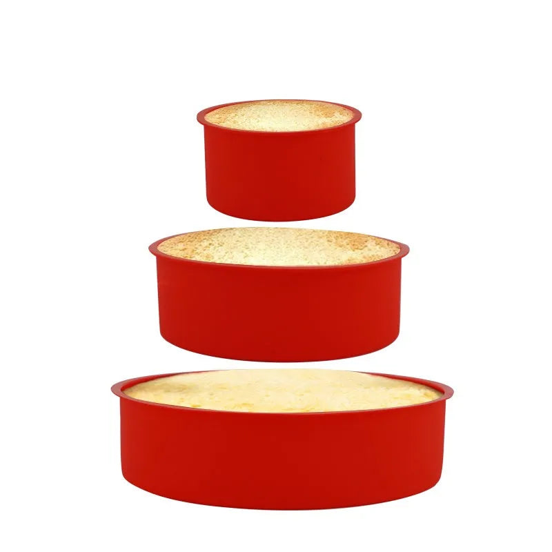 Set of three bright red round silicone cake moulds in 4-inch, 6-inch, and 8-inch sizes on a kitchen counter.